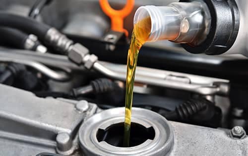 Oil being poured into a vehicle